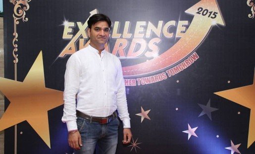 Praveen standing in front of banner
